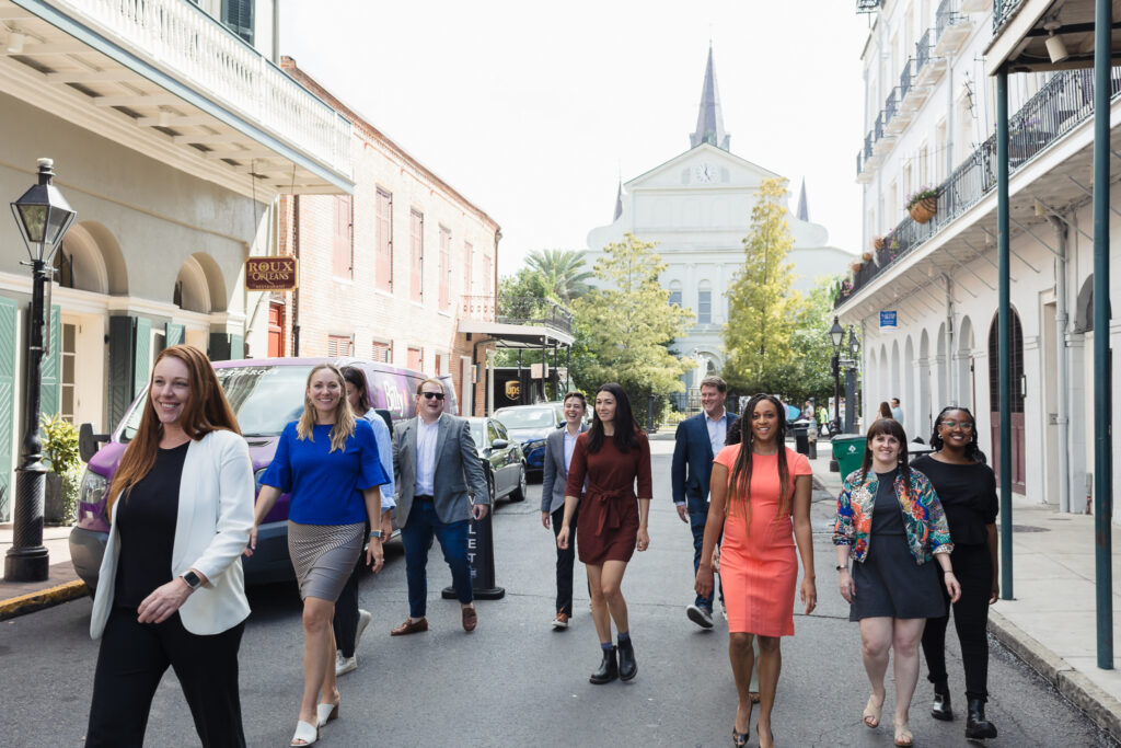 A group of professional communicators walking confidently down a city street, embodying leadership and the drive for social change.